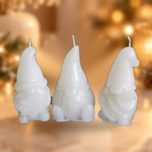 Bougie Trio de lutins blancs, modèle original, photographie d'ambiance Noël sur fond chaud beige avec lumières dorées