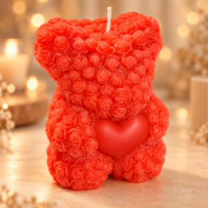 Bougie ourson rouge composée de roses sculptées et tenant un cœur rouge, mise en scène chaleureuse